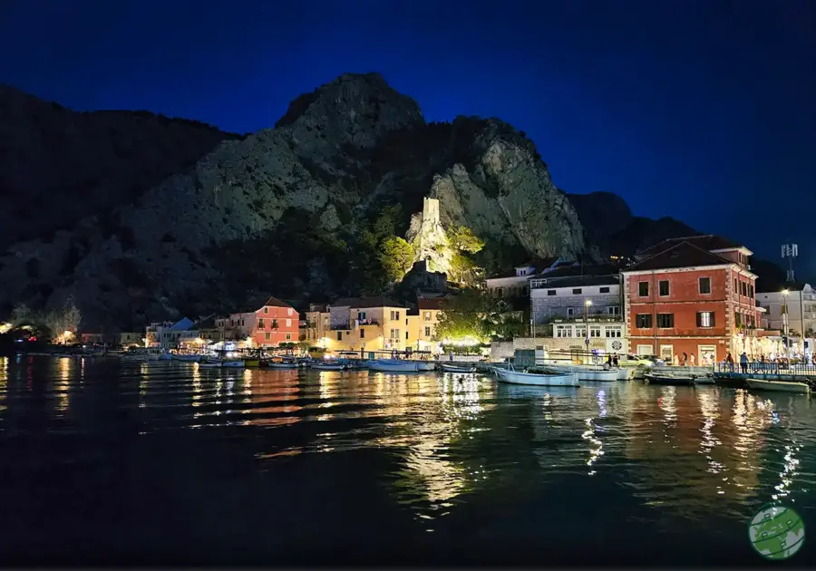 Omiš à noite com as luzes a refletirem na agua e fortaleza